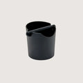 Black plastic coffee waste knock box container on a light gray background