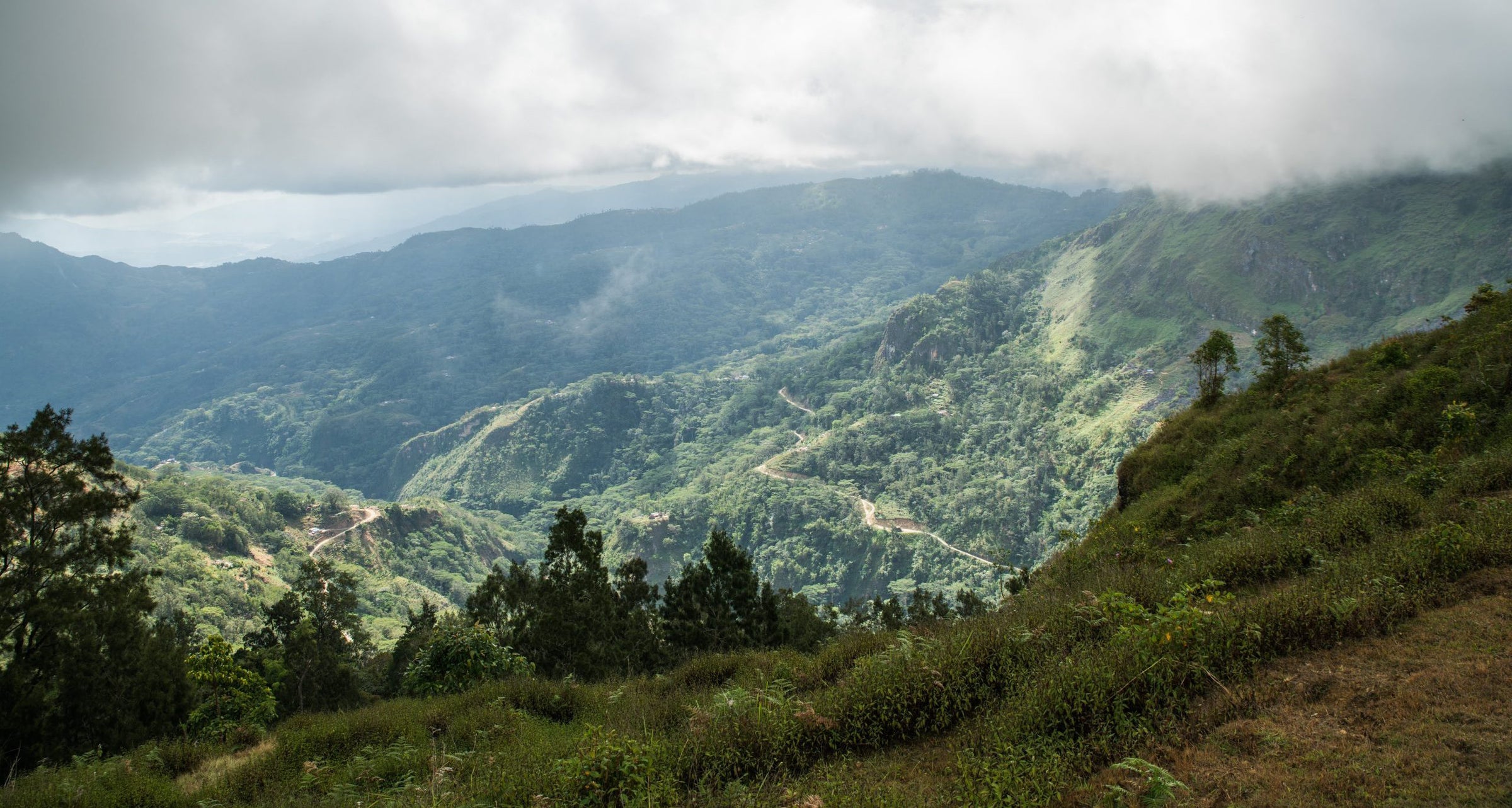 Scenic view of lush green mountains in Timor with a cloudy sky