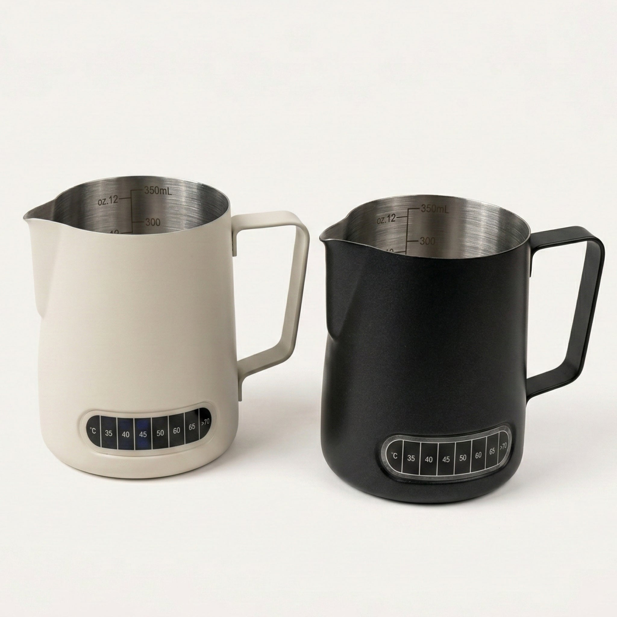 Two Thermosense milk jugs with built-in thermometer in beige and black. 