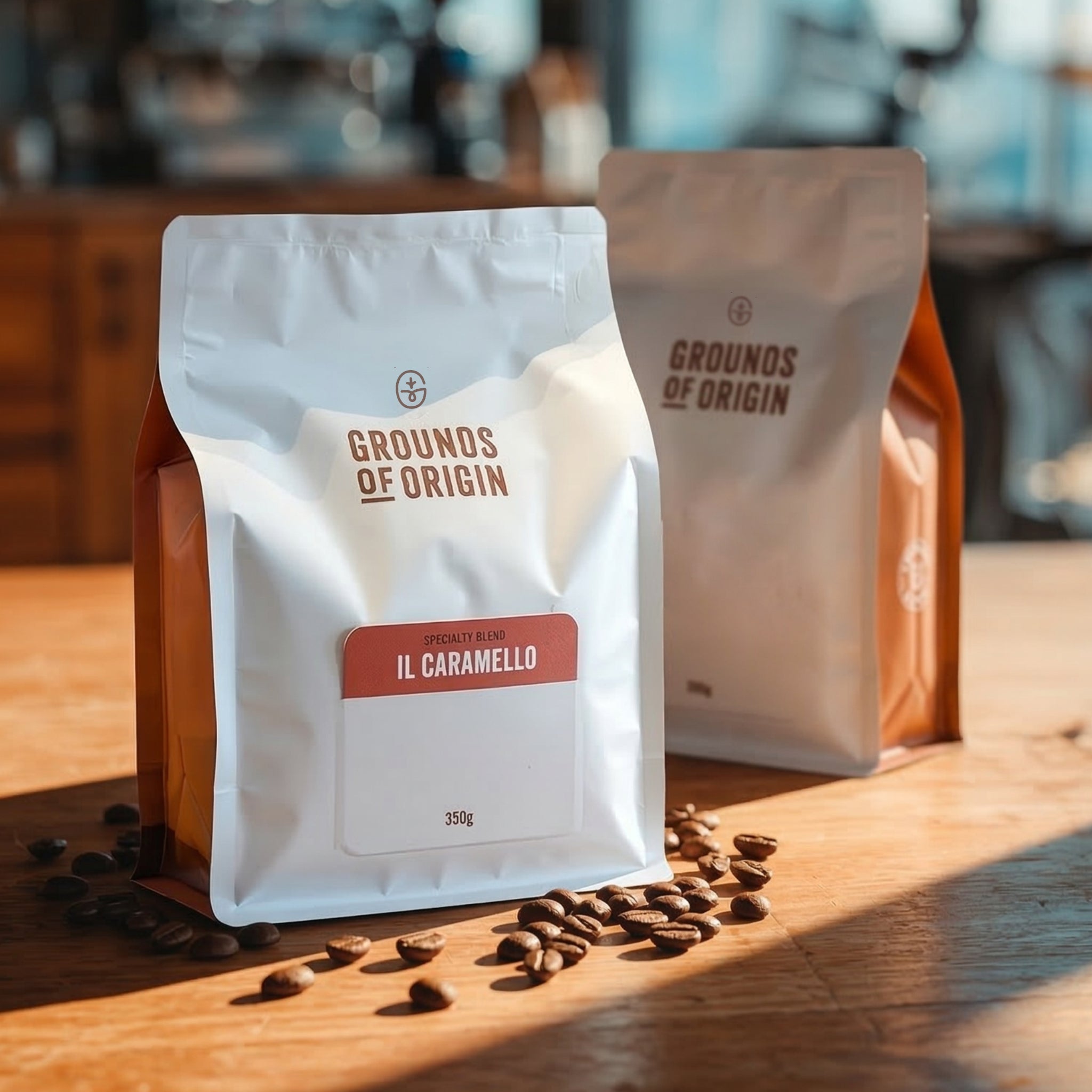 Two coffee bags labeled 'Grounds of Origin' on a wooden surface with scattered coffee beans.