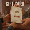 Two people gifting a 'Grounds of Origin' coffee bag with 'Il Caramello' flavor, labeled as a gift card.
