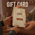 Two people gifting a 'Grounds of Origin' coffee bag with 'Il Caramello' flavor, labeled as a gift card.