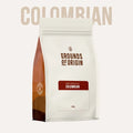 Coffee bag labeled 'Grounds of Origin' with 'Colombian' text on a white background