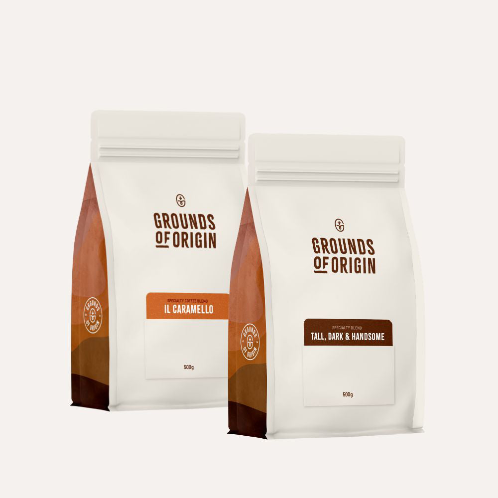Two 'Grounds of Origin' coffee bags on a white background