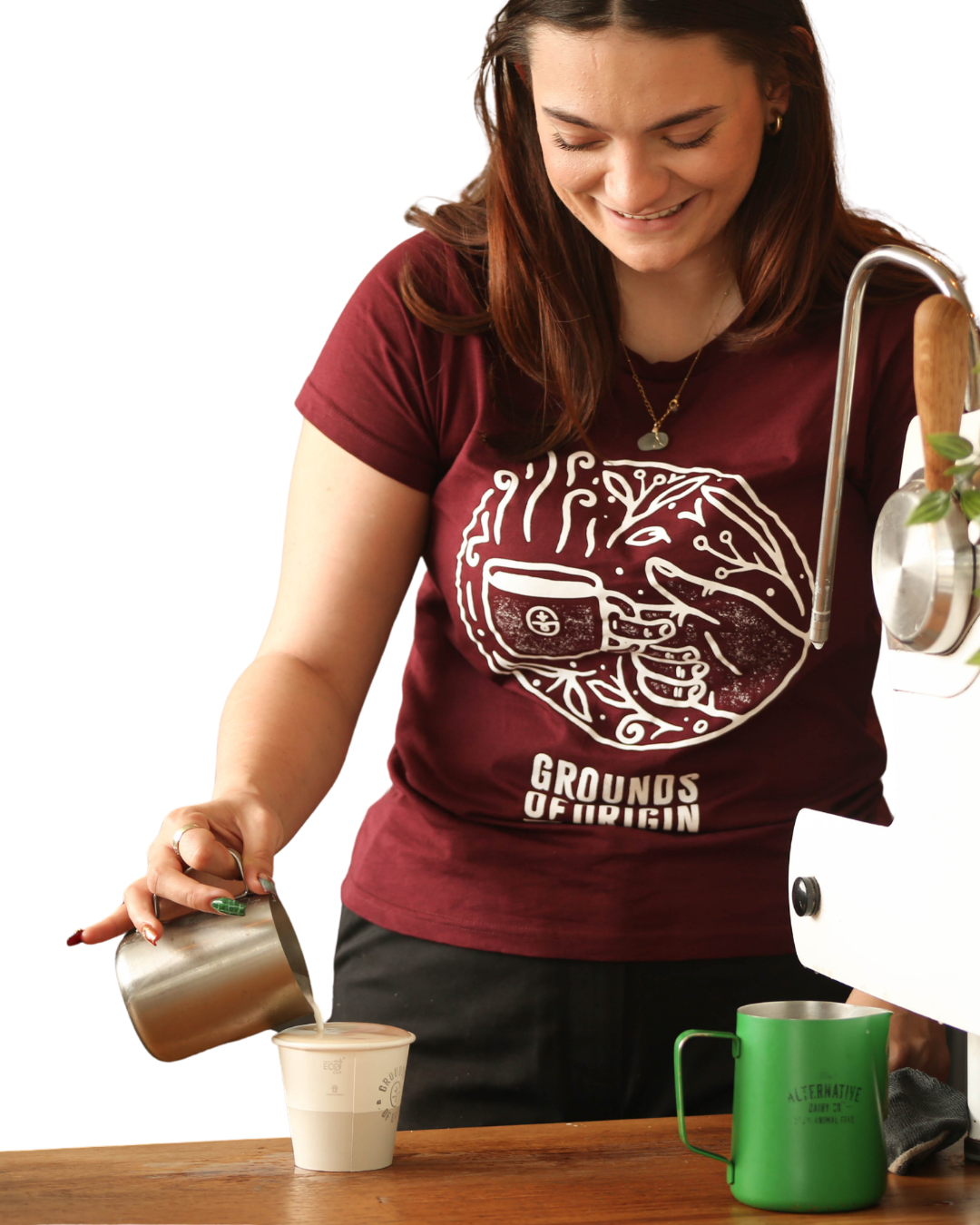Woman pouring coffee into a cup wearing a 'Grounds of Origin' t-shirt.
