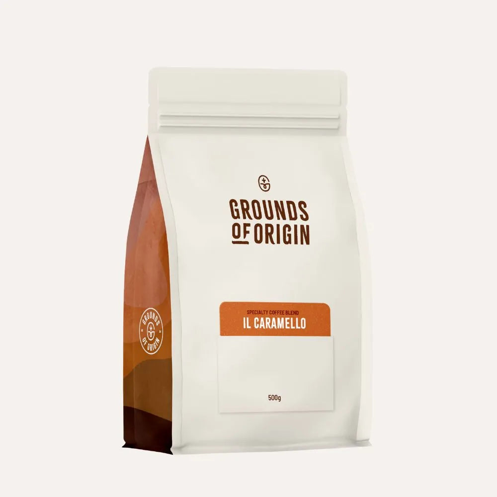 Coffee bag labeled 'Grounds of Origin' with 'Il Caramello' flavor on a white background