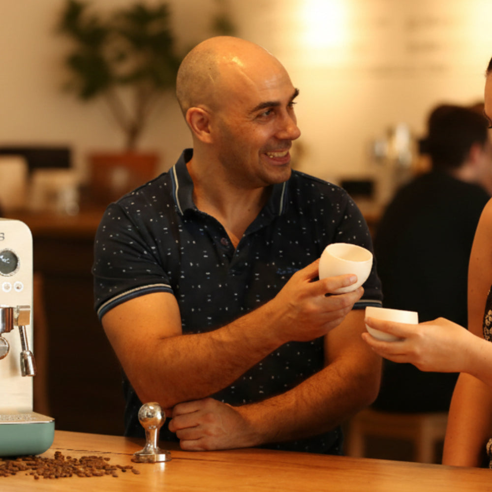 Ryde Jeavons holding a coffee cup in a cafe setting