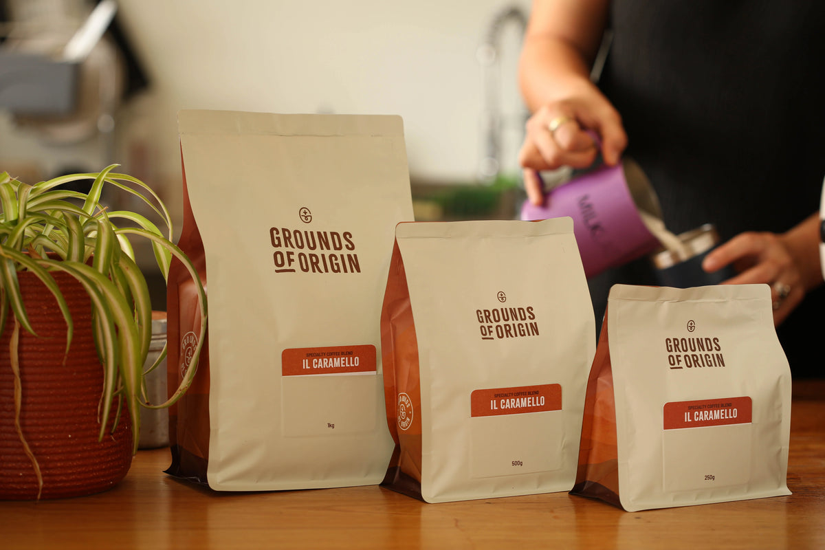 Three bags of 'Grounds of Origin' Il Caramello coffee on a cafe counter.