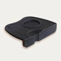 Blackrubber tamper mat with a central circular component on a white background